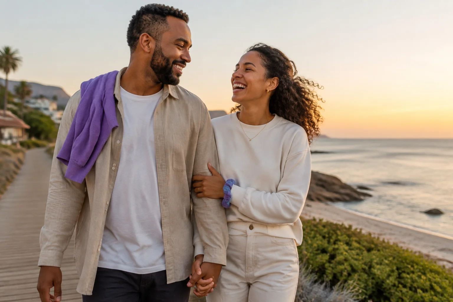 Casal feliz caminhando em um calçadão à beira-mar